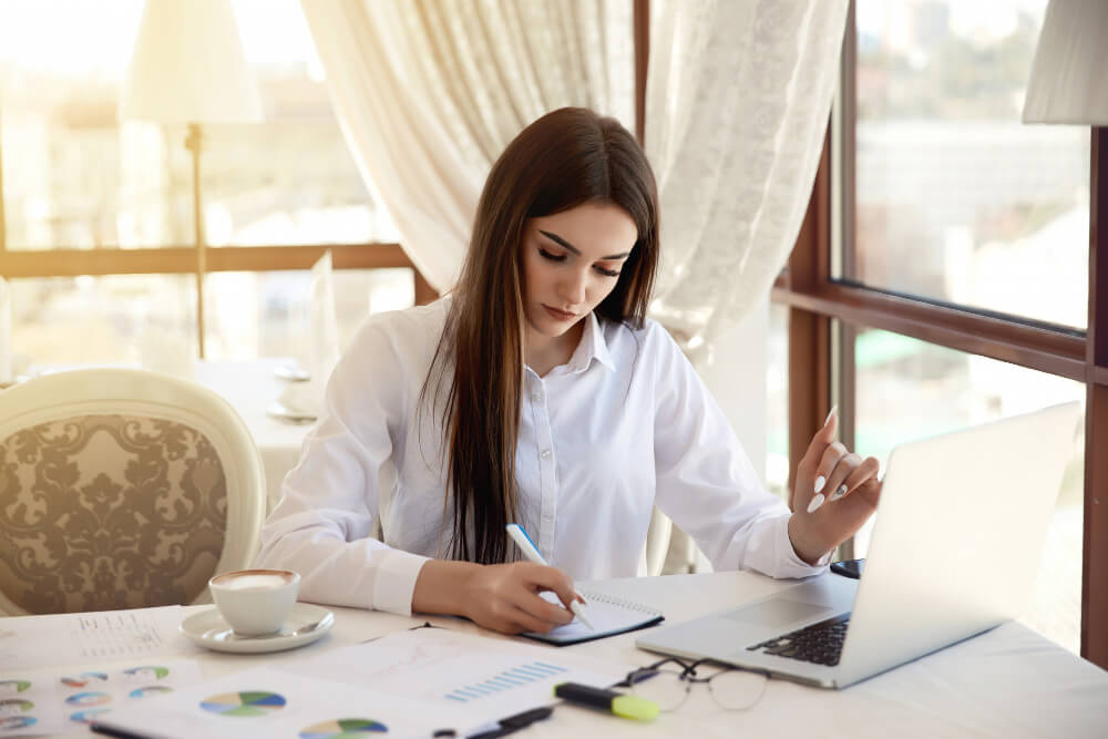 Women-Student-drafting-business-report-in-office